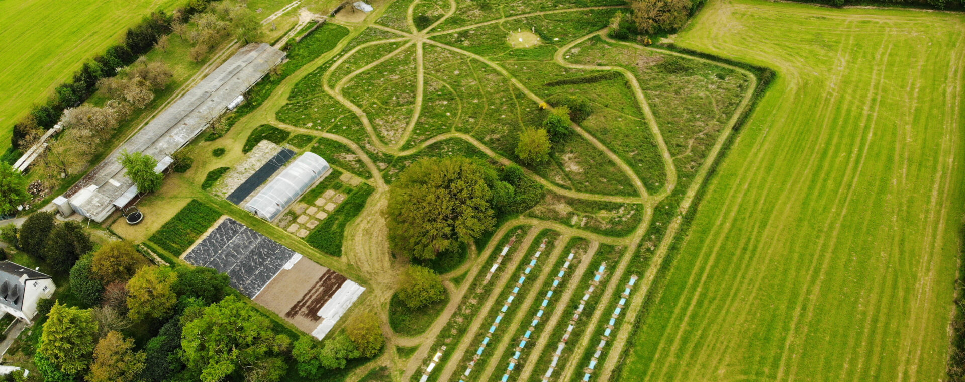 Vue aérienne, prise au drone d'une ferme en maraichage en permaculture. On repère des plantations et des chemins de déambulation autour desquels seront planter les arbres du jardin foret. Il s'agit de la structure de Keyll Foret Jardin